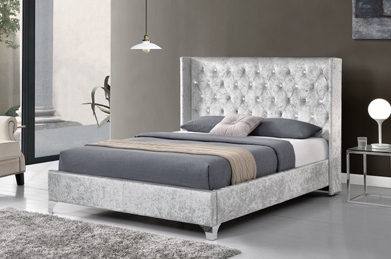 Un lit rembourré de grande taille avec des boutons en cristal